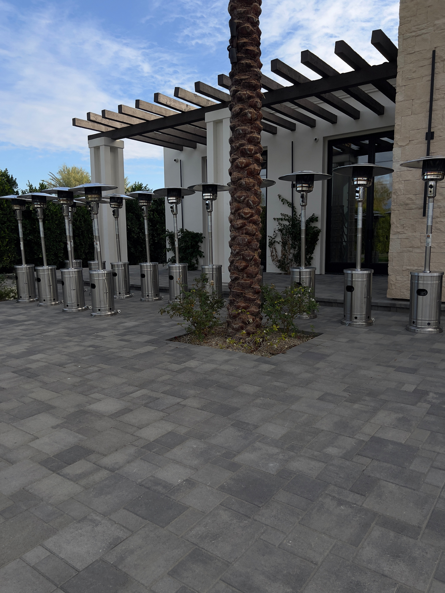 Round tables with silver chiavari chairs and commercial patio heaters