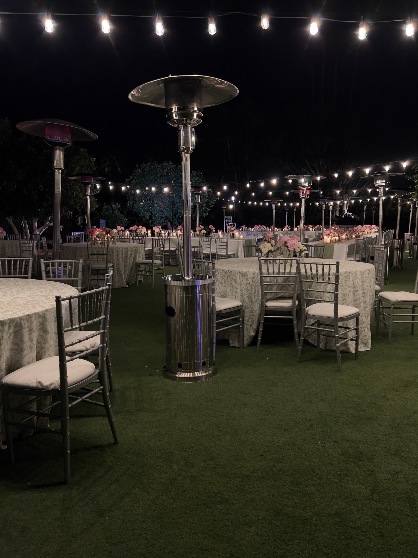 Long tables set up with patio heaters at a modern desert venue